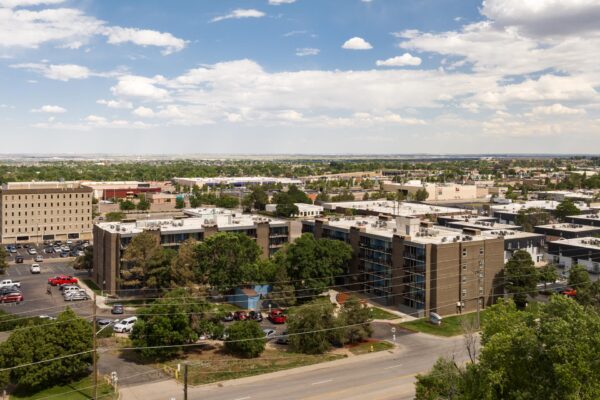 Beacon House apartments with classic brick construction, large balconies, and tall trees.