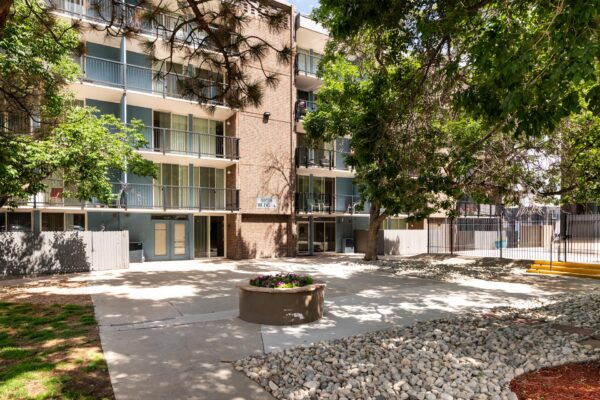 Beacon House apartments courtyard with tall trees and paved walkways.