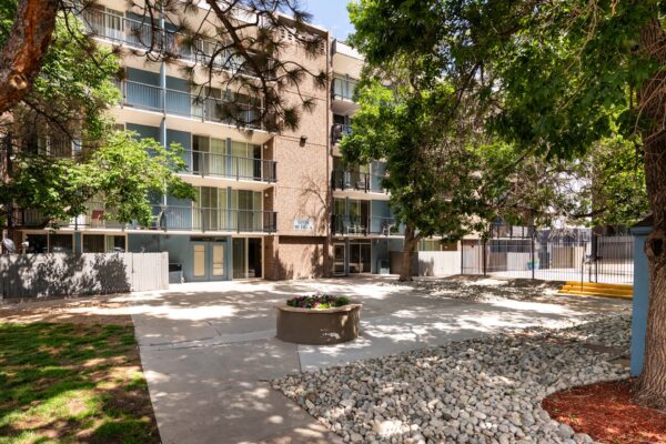 Beacon House apartments courtyard with tall trees and paved walkways.