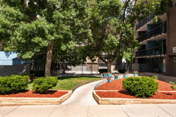 Beacon House apartments courtyard with lush landscaping and tall trees.