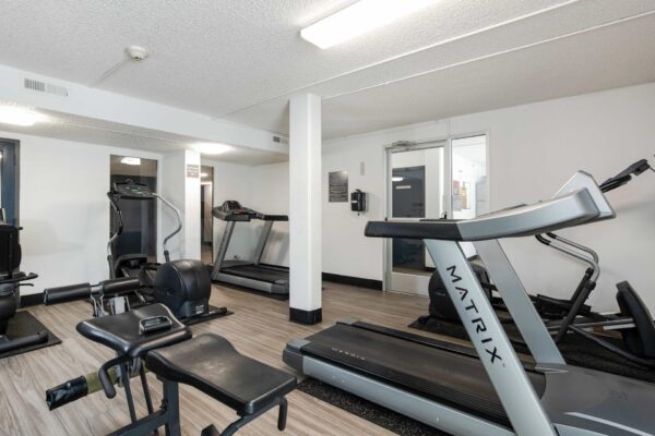 Beacon House apartments fitness center with cardio machines and weight equipment.