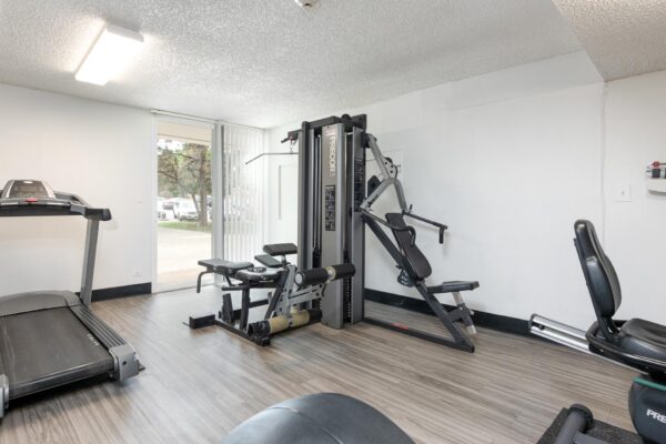 Beacon House apartments fitness center with cardio machines and weight equipment.