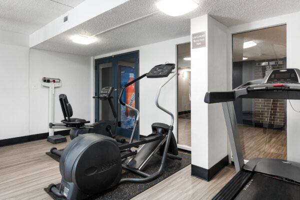 Beacon House apartments fitness center with cardio machines and weight equipment.