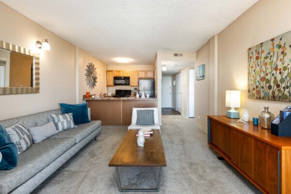 Beacon House apartment living room with plush carpet, mid century modern furniture, and wall art.