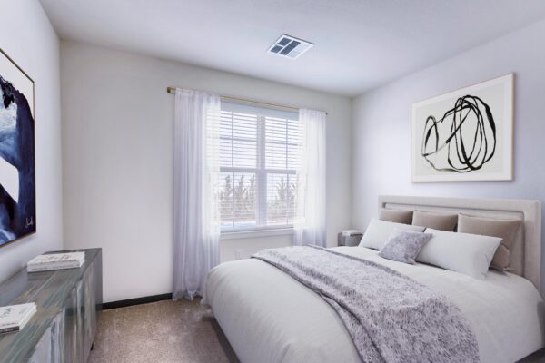 Centre Court apartment bedroom with carpet, plush bed with headboard, large window, and artwork.