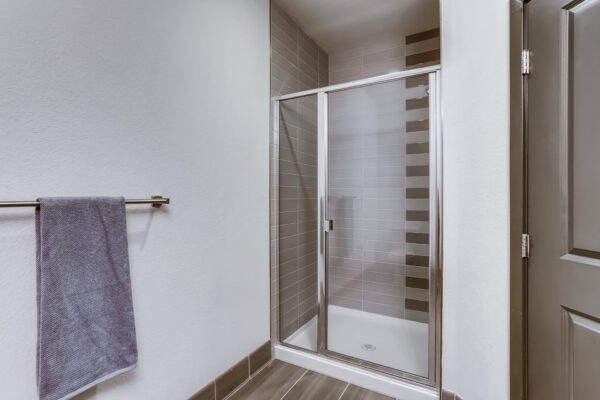 Centre Court apartment bathroom with tiled glass door shower.