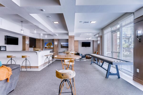 Centre Court apartments clubroom with community kitchen, shuffleboard table, and TV lounge.