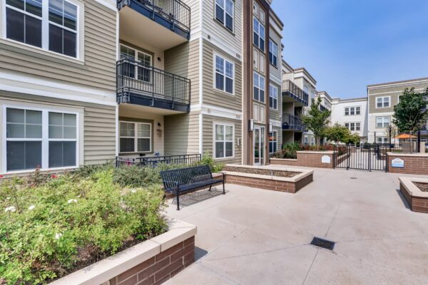 Centre Court apartments courtyard with lush planters and paved walkways.