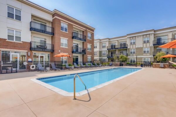 Centre Court apartments pool area with lounge chairs and umbrellas.