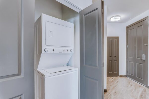 Centre Court apartment laundry closet with stacked washer dryer machine.