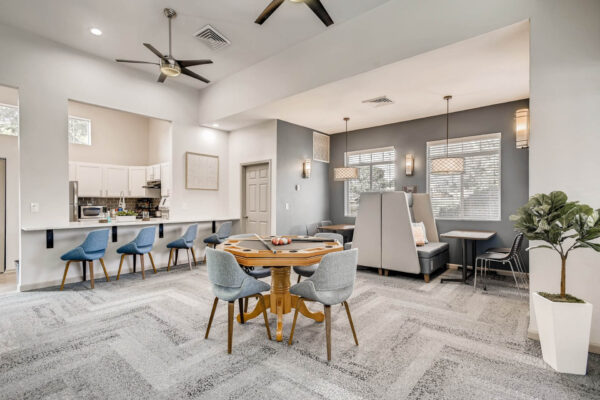 Copper Ridge apartments clubroom with community kitchen, games table, and cozy booths.