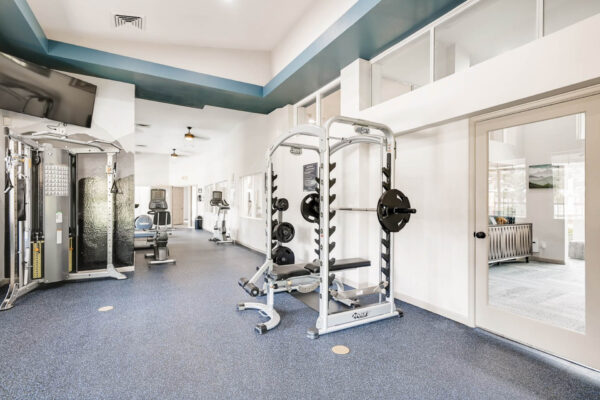 Copper Ridge apartments fitness center with weight equipment and large windows.