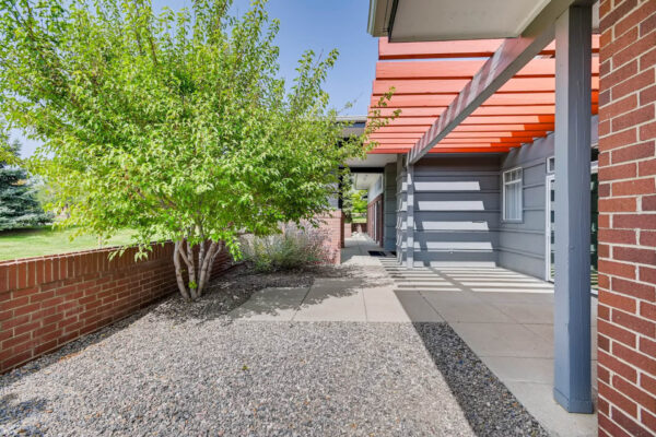 Copper Ridge apartments exterior with red pergola and tall trees.