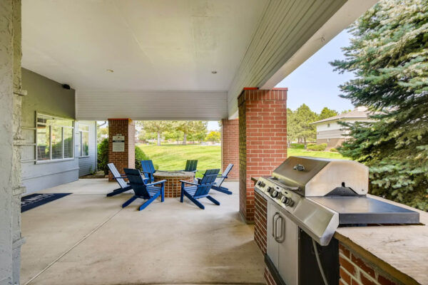 Copper Ridge apartments outdoor lounge with fire pit, lounge chairs, and BBQ grill.