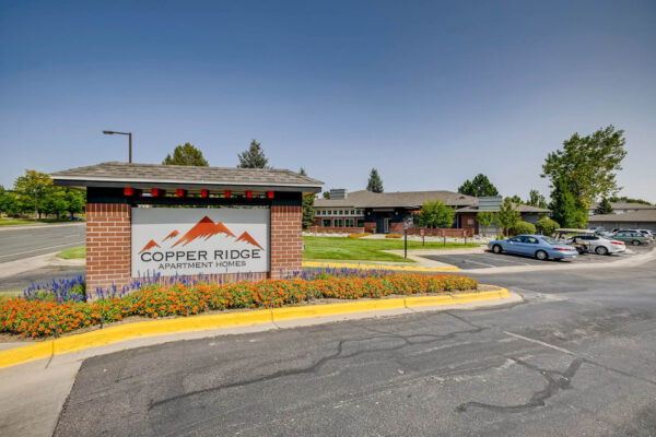 Copper Ridge apartments monument sign with lush flowerbed.