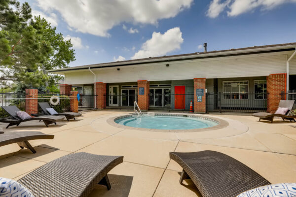 Copper Ridge apartments hot tub area with lounge chairs and metal fencing.