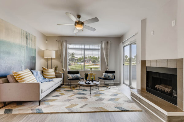 Copper Ridge apartment living room with wood style floor, fireplace, plush seating, large windows, and balcony door.