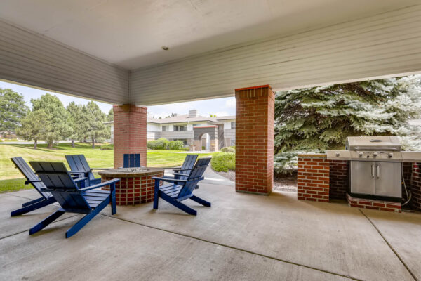 Copper Ridge apartments outdoor lounge with fire pit, lounge chairs, and BBQ grill.