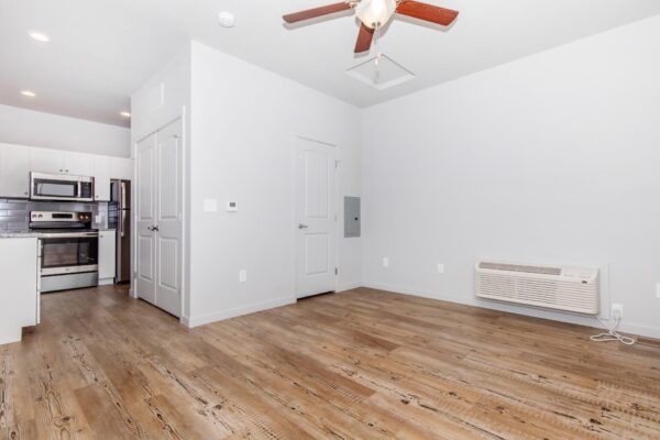 Cottages at Jet Wing apartment living room with wood style floor, ceiling fan, and air conditioning.