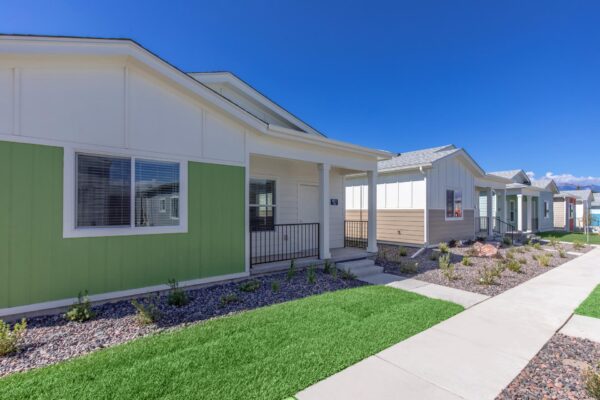 Cottages at Jet Wing apartments with lush green lawns and colorful accent paints.