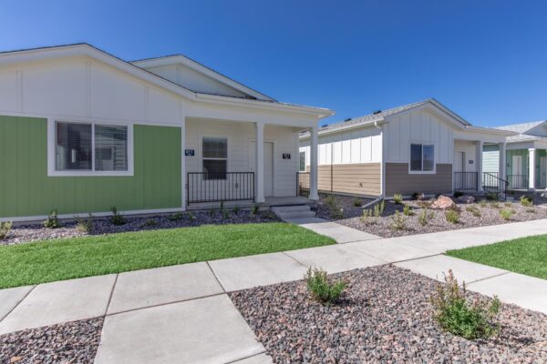 Cottages at Jet Wing apartments with lush green lawns and colorful accent paints.