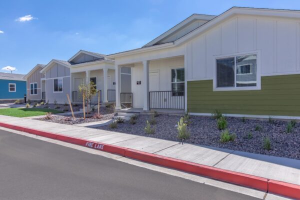 Cottages at Jet Wing apartments with rocky landscaping and colorful accent paint.