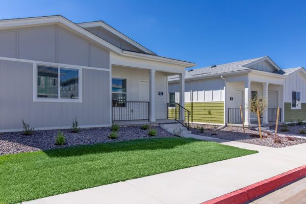 Cottages at Jet Wing apartments with lush green lawns and colorful accent paint.