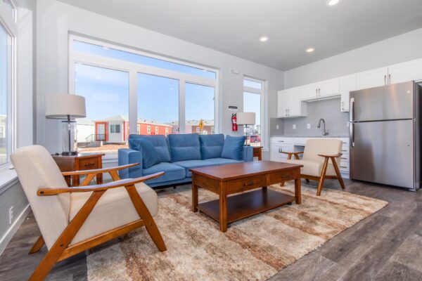 Cottages at Turin Point apartments common area with plush seating, large windows, and fridge.