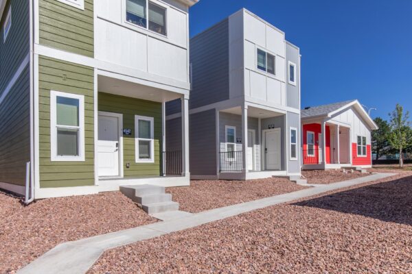 Cottages at Turin Point apartments with rocky landscaping and colorful buildings.
