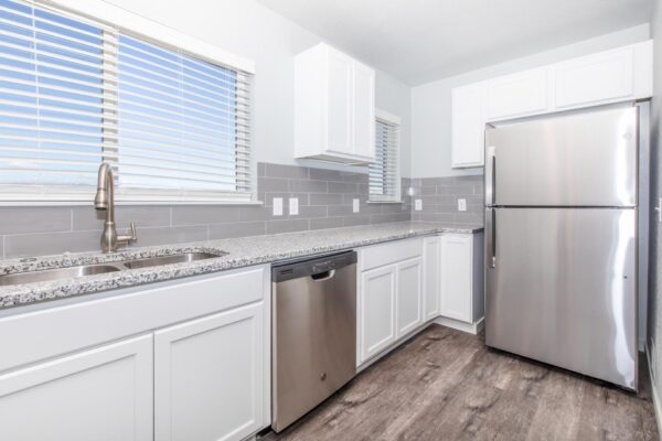 Cottages at Torin Point apartment kitchen with wood style floor, white cabinets, and stainless steel appliances.
