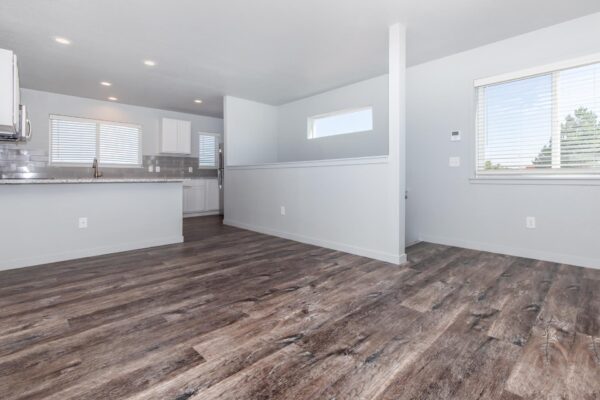 Cottages at Torin Point apartment living area with wood style floor, gray walls, and large windows.