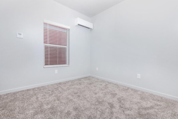 Cottages at Torin Point apartment bedroom with plush carpet and large window.