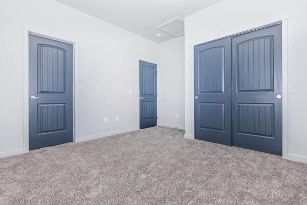 Cottages at Torin Point apartment bedroom with plush carpet and blue doors.