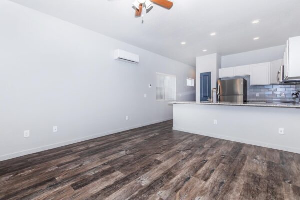 Cottages at Torin Point apartment living area with wood style floor, breakfast bar, and ceiling fan.