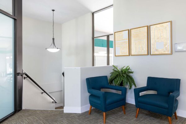 Flats at Pinecliff apartment lounge with plush seating and framed artwork.