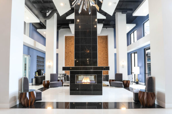 Forum Fitzsimons apartments with plush seating and black tile fireplace.