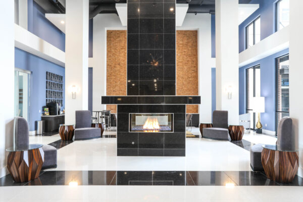 Forum Fitzsimons apartments clubroom with large shiny black tiled fireplace.