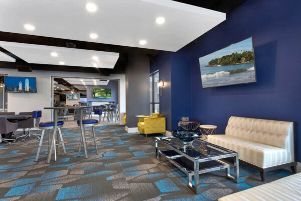 Forum Fitzsimons apartments lounge with plush seating and TV.