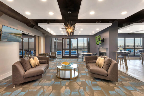 Forum Fitzsimons apartments lounge with plush seating and fireplace.