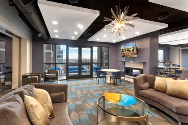 Forum Fitzsimons apartments lounge with plush seating and fireplace.