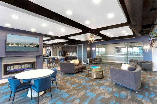 Forum Fitzsimons apartments lounge with plush seating, TV, and fireplace.