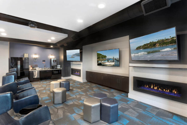 Forum Fitzsimons apartments lounge with plush seating, fireplaces, and TVs.