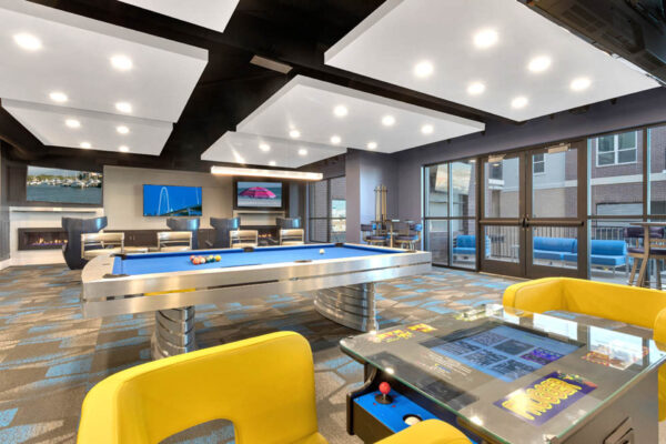 Forum Fitzsimons apartments lounge with arcade games and pool table.