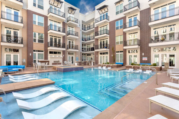 Forum Fitzsimons apartments pool area with lounge chairs and outdoor couches.