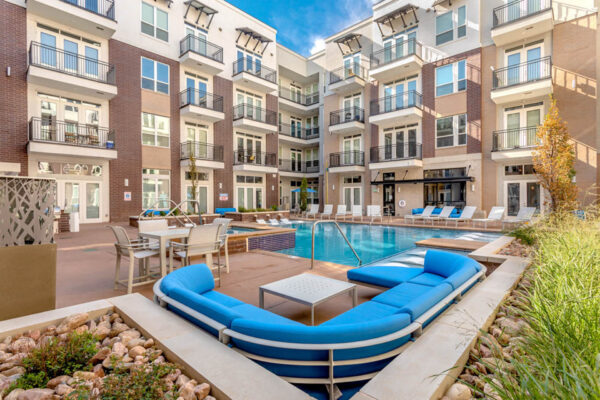 Forum Fitzsimons apartments pool area with lounge chairs, hot tub, and outdoor couch.