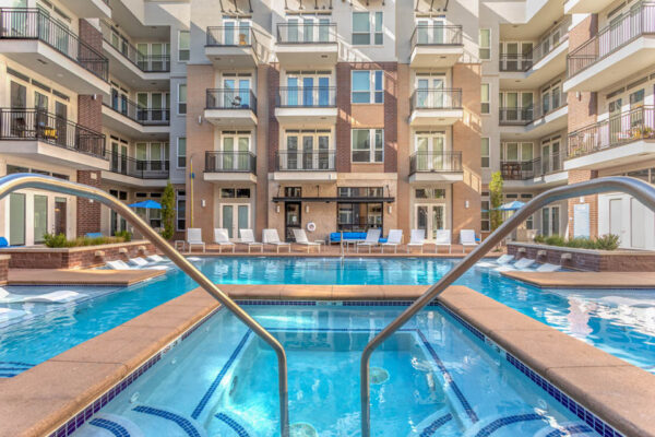 Forum Fitzsimons apartments pool area with lounge chairs and hot tub.