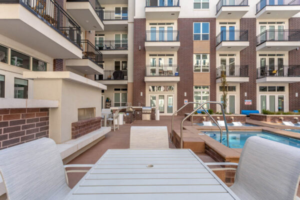 Forum Fitzsimons apartments pool area with fireplace and dining table.
