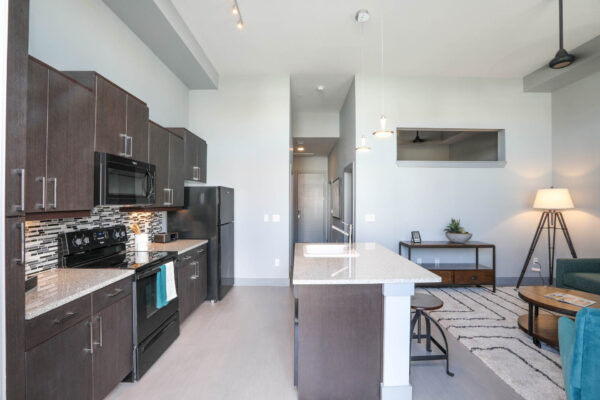 Forum Fitzsimons apartment living space with comfortable seating and modern kitchen.