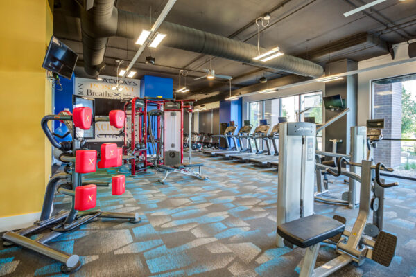 Forum Fitzsimons apartments fitness center with cardio machines and weight equipment.