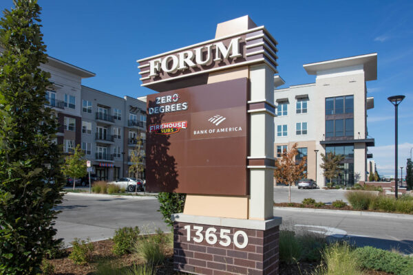 Forum Fitzsimons apartments signage with lush landscaping.